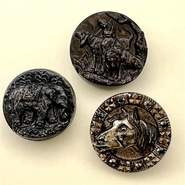 Three black glass buttons of animals.