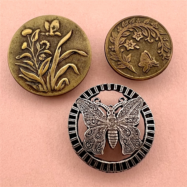 Three metal buttons of butterflies.