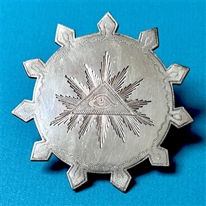 Huge chased and silvered metal button of the “Eye of Providence.”