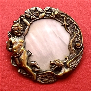 Shell set in brass button with elaborate pictorial border.