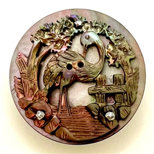 Carved shell button of a crane on shell.