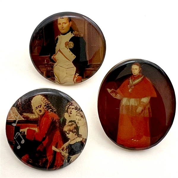 Three studio buttons of famous people under resin.