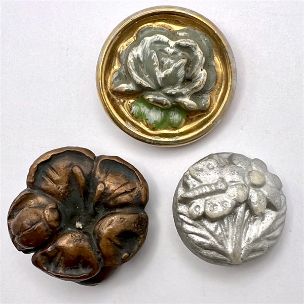 Three ceramic and acrylic shot buttons of flowers.