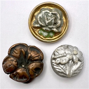 Three ceramic and acrylic shot buttons of flowers.