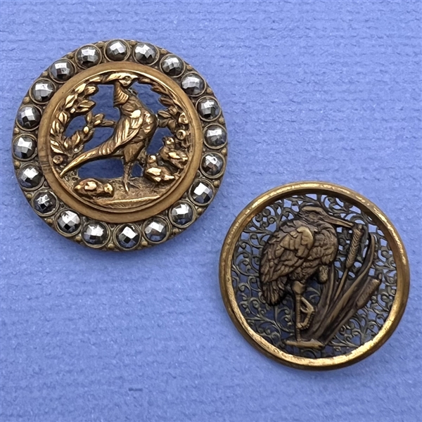 Two brass buttons of birds with open work.