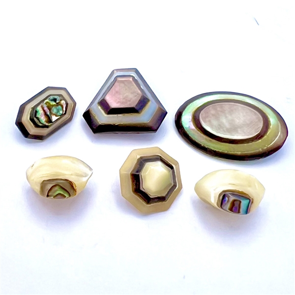 Six laminated pearl and shell buttons.