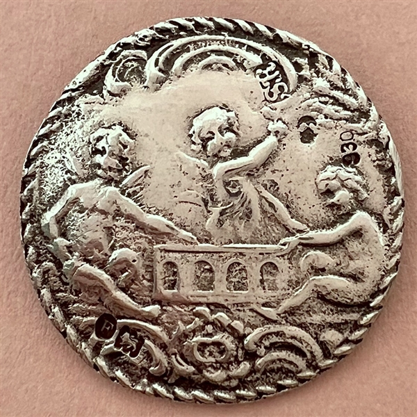 Hallmarked silver button of three cherubs.