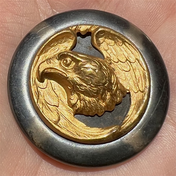 Brass eagle on celluloid button.