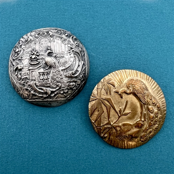 Two metal buttons of peacocks.