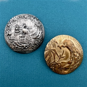 Two metal buttons of peacocks.