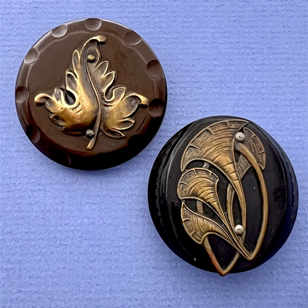 Two Vintage plastic coat buttons with brass leaves.