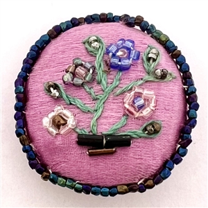 A 19th c. Fabric button of a flower arrangement.