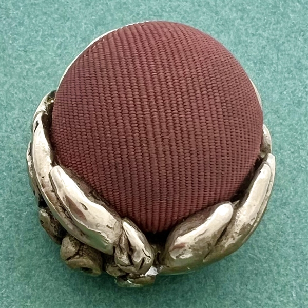 Metalized British Bakelite hands holding fabric ball button.