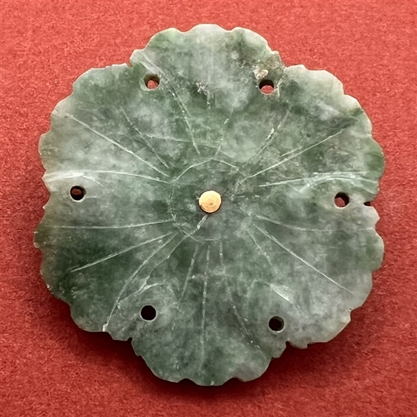 Carved jade button of a realistic flower.