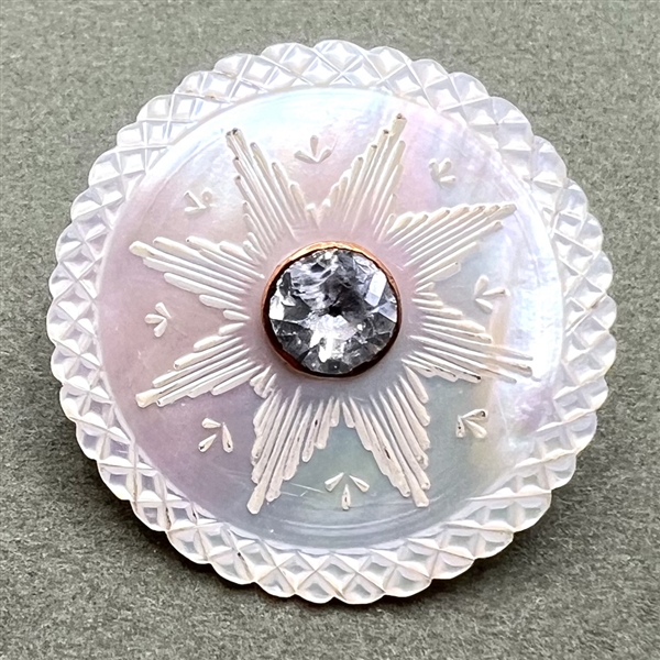 An 18th c. carved mother of pearl button with faceted paste center.