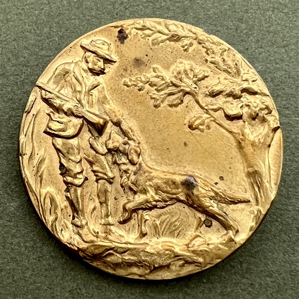 Stamped brass button of a hunter and his dog. 