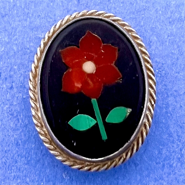 A Pietra Dura button set in silver of a flower.