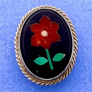 A Pietra Dura button set in silver of a flower.