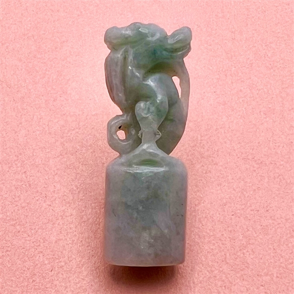 Carved jade button of a fabulous creature.