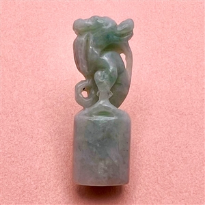 Carved jade button of a fabulous creature.