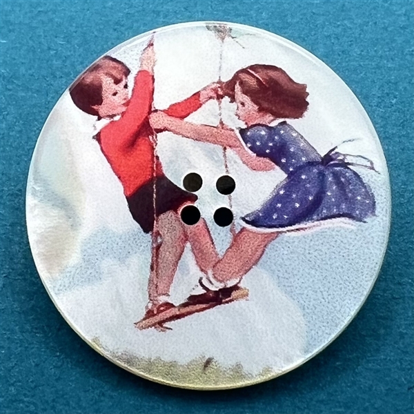 Transfer on iridescent shell button of two children on a swing.