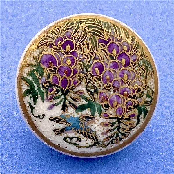 Satsuma button of a bird flying under Wisteria.