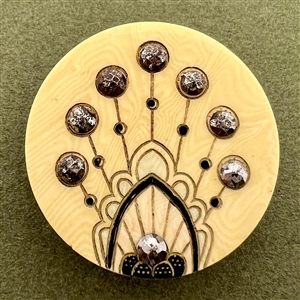 Celluloid button with facetted steels.