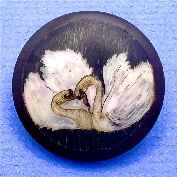 Natural material button of two swans.