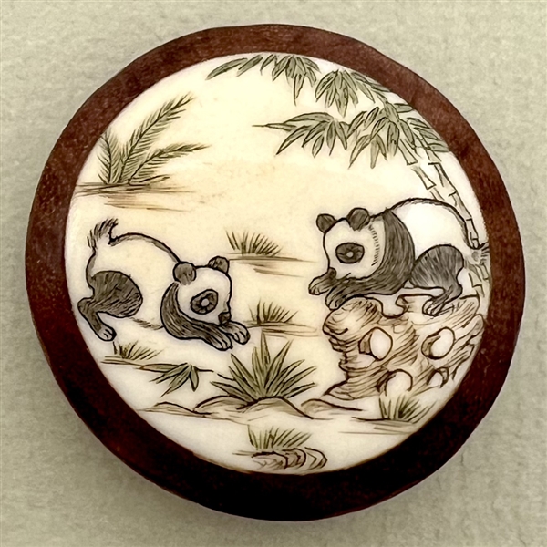 Natural material button of two pandas.