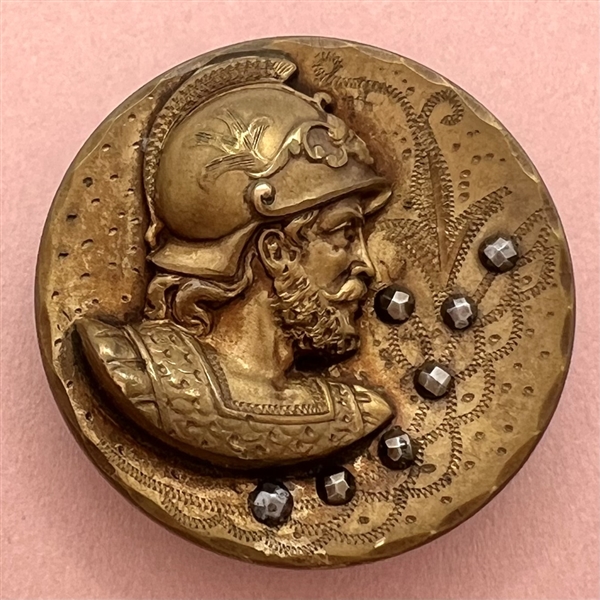 Large brass button of a head of a warrior.