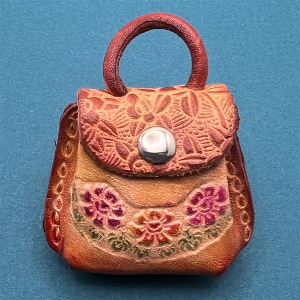 Tooled leather button of a realistic purse.