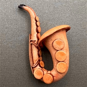 Large realistic leather button of a saxophone. 