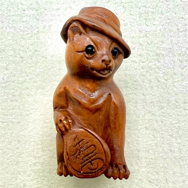 Boxwood button of cool cat in a hat.