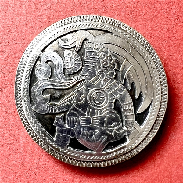 White metal button of Aztec god.