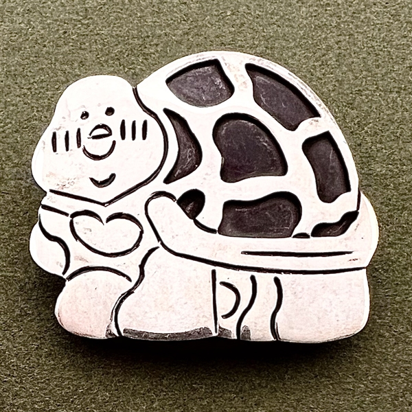 Silver button of a turtle.