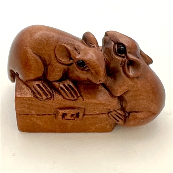 Mice climbing on a suitcase wood button.