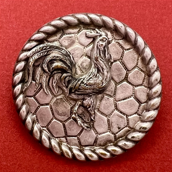 White metal button of a rooster.