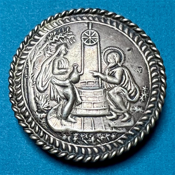 Extra large silver button of “Rebecca and Eliezer at the Well.”