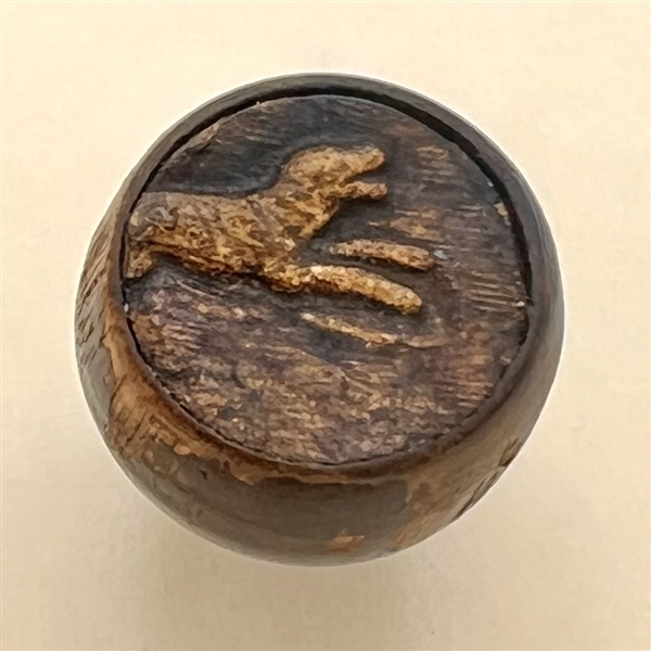 Embossed leather on wood button of a dog. 