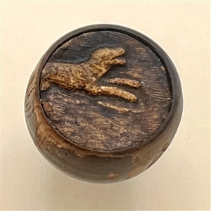 Embossed leather on wood button of a dog. 