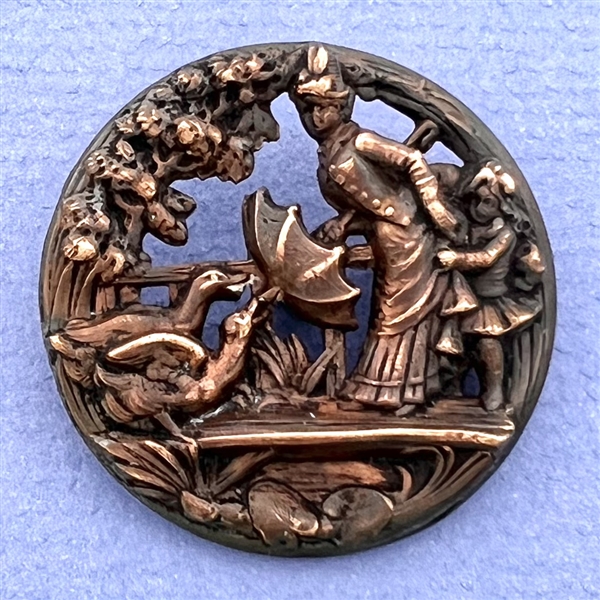 Stamped and pierced brass button of “Woman Shooing Geese.”