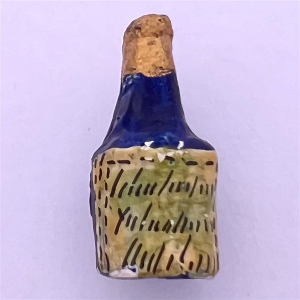 Little papier maché button of champagne bottle.