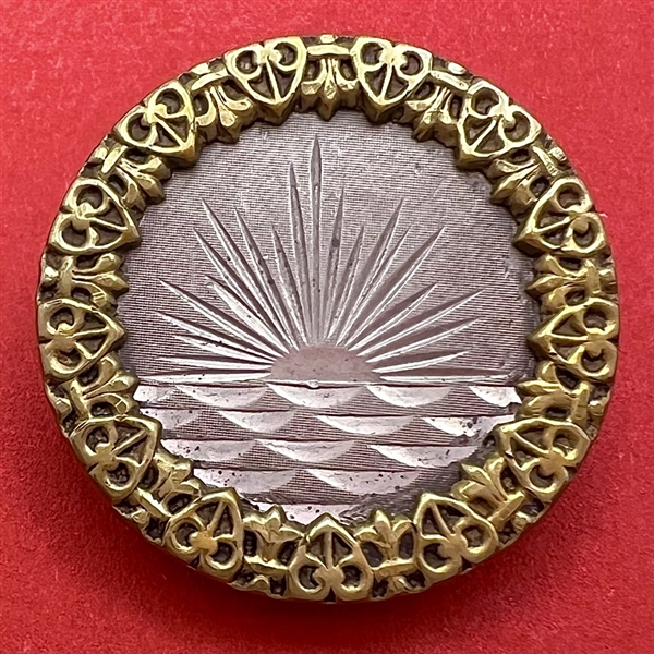 A 19th c. pewter button of sunset over water.