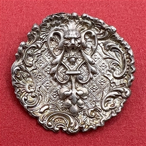 White metal “door knocker” button.