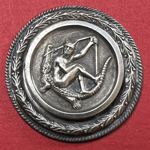 French white metal button of the devil sitting on an alligator.