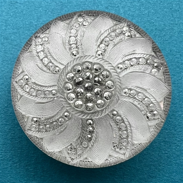 Lacy glass button with an interesting pattern.