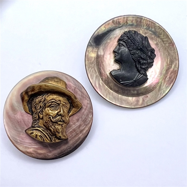 Two smoky pearl buttons of heads.