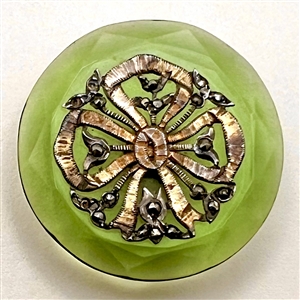 Transparent green glass button with bow.