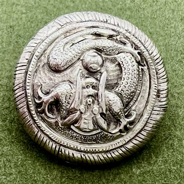 Highly sculptural silver button of a dragon.