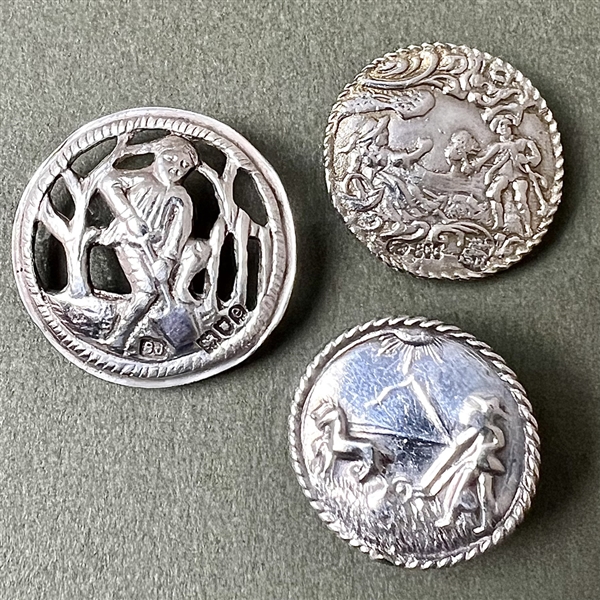 Three hallmarked silver buttons of people.